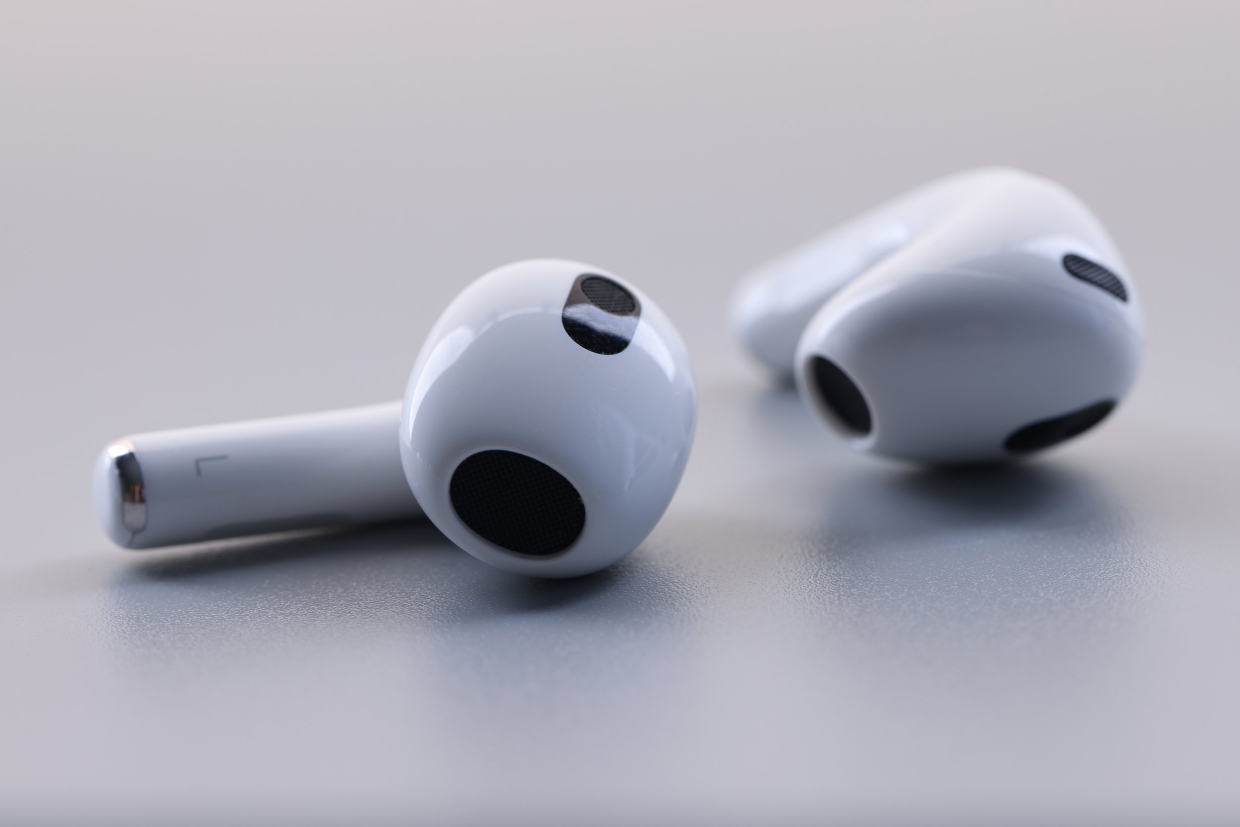 Closeup of New Wireless Headphones Apple Airpods 3 on White Background